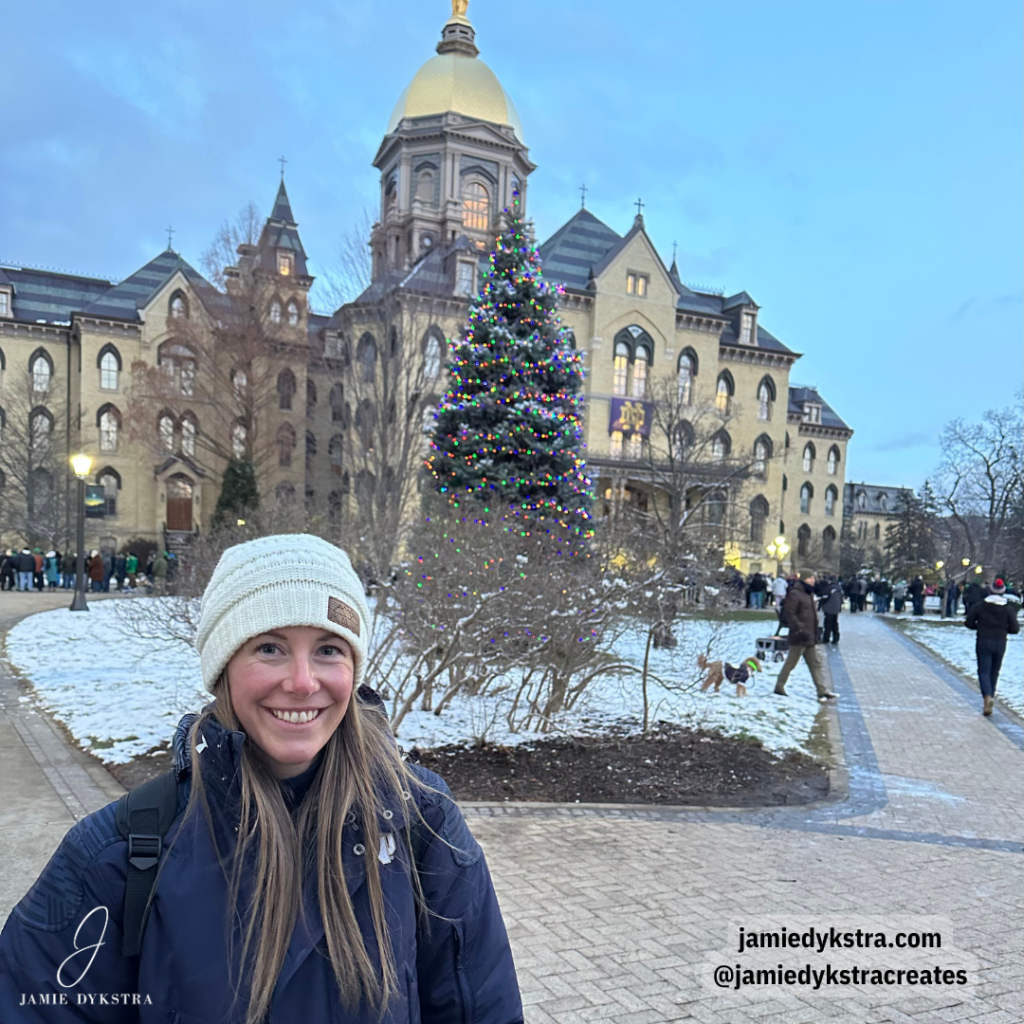 A picture of me standing in front of the Golden Dome at Notre Dame with a Christmas tree in the background.
