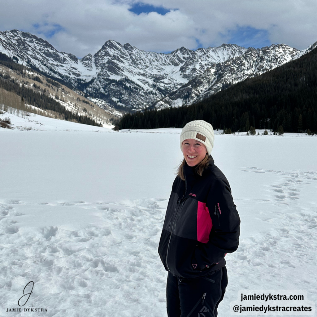 I picture of me standing on a snowy lake in front of a snow covered mountain range.