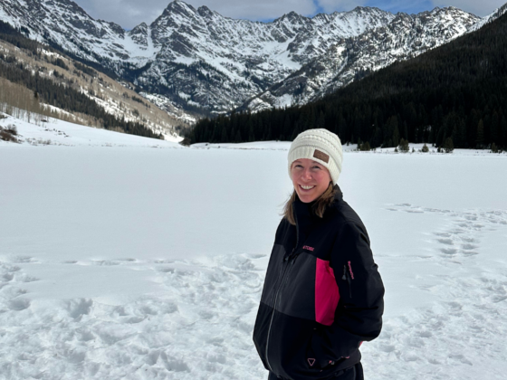 I picture of me standing on a snowy lake in front of a snow covered mountain range.