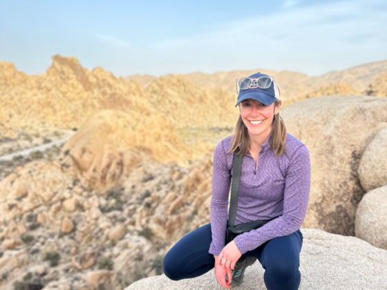 A picture of me squatting down on the top of a rock scramble in Joshua Tree National Park.