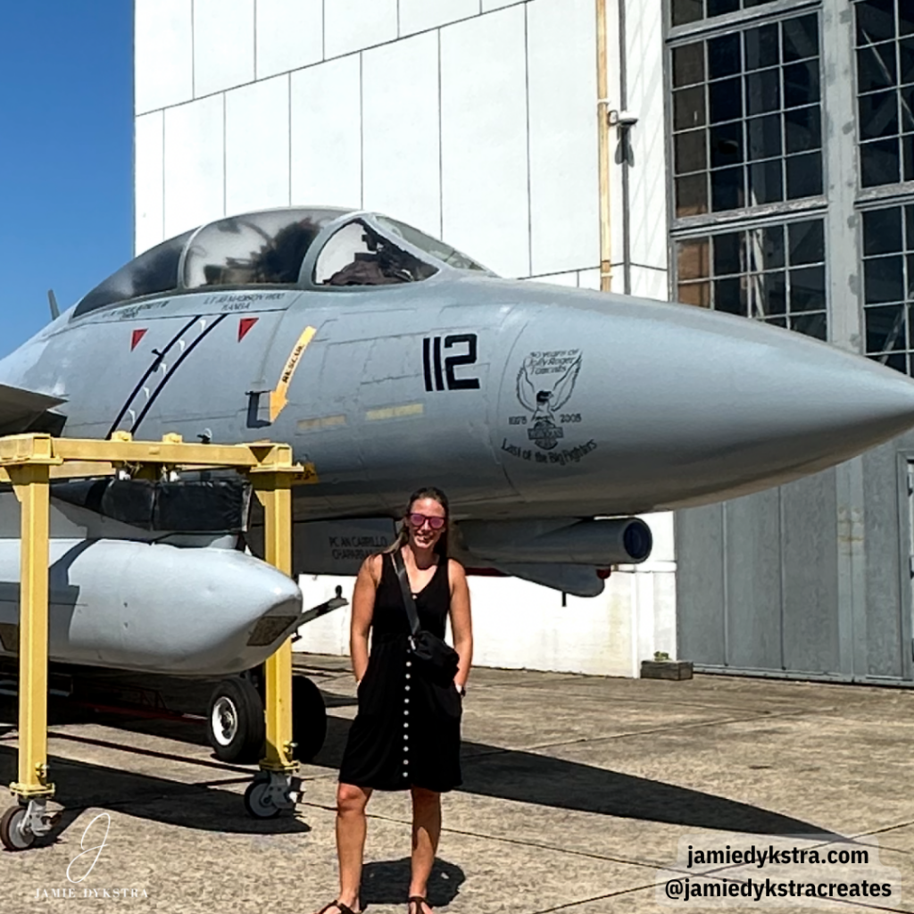 I picture of me outside at a museum next to an old fighter plane.