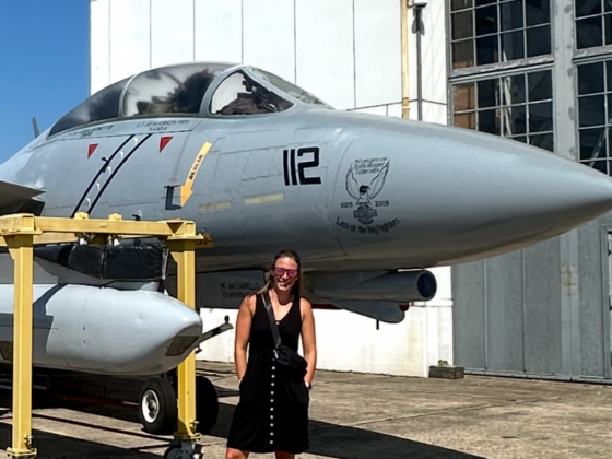 I picture of me outside at a museum next to an old fighter plane.