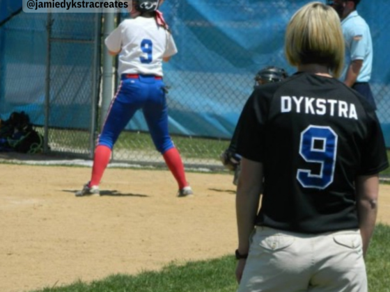 A picture of me in a black softball jersey coaching on the third base line.