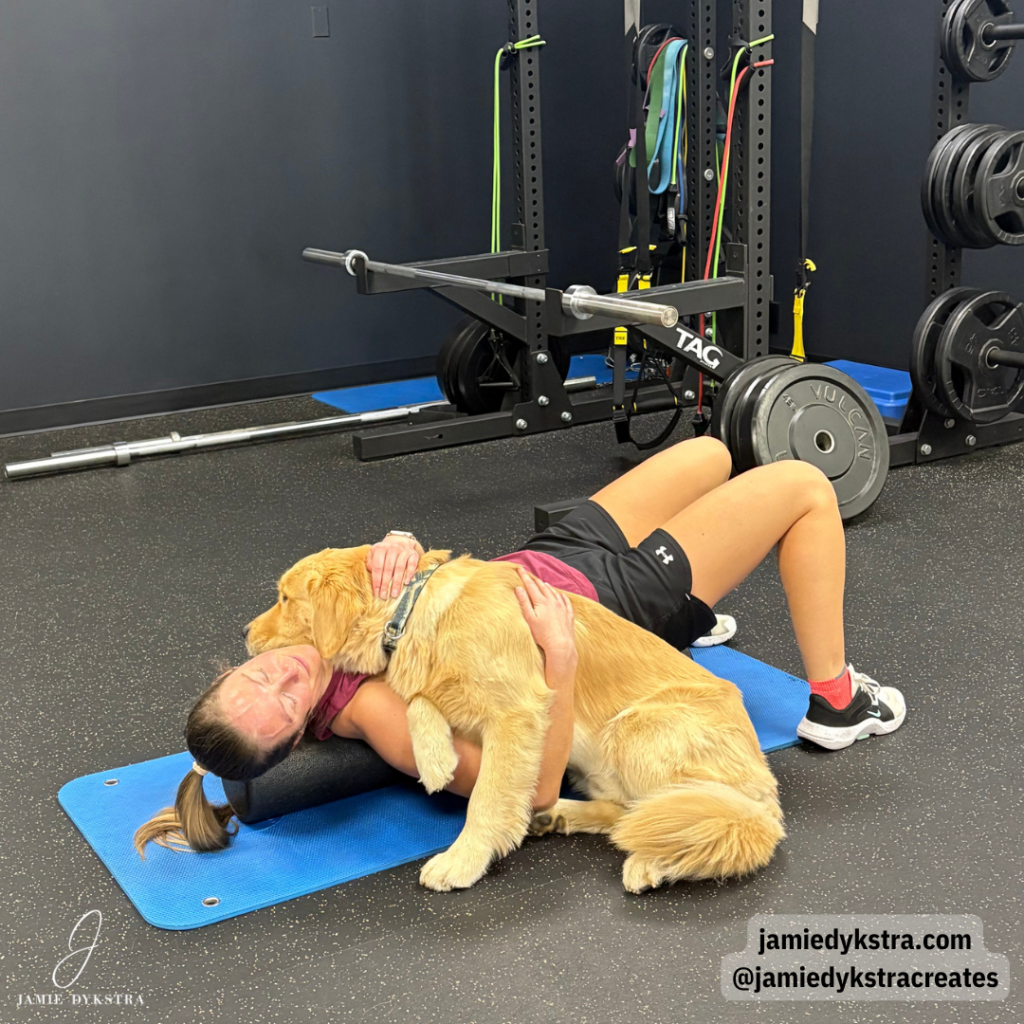 A picture of me stretching after a workout with my Golden Retriever laying on me.