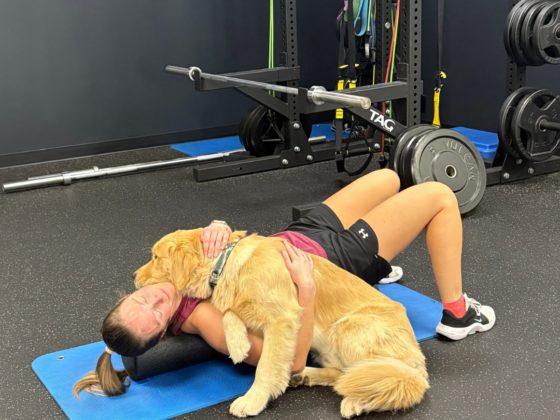 A picture of me stretching after a workout with my Golden Retriever laying on me.