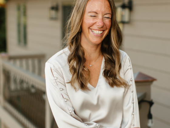 A picture of me leaning against a railing with one arm crossed, laughing.
