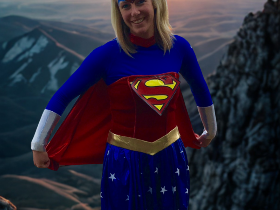 A picture of me in a superwoman costume with AI mountains in the background.