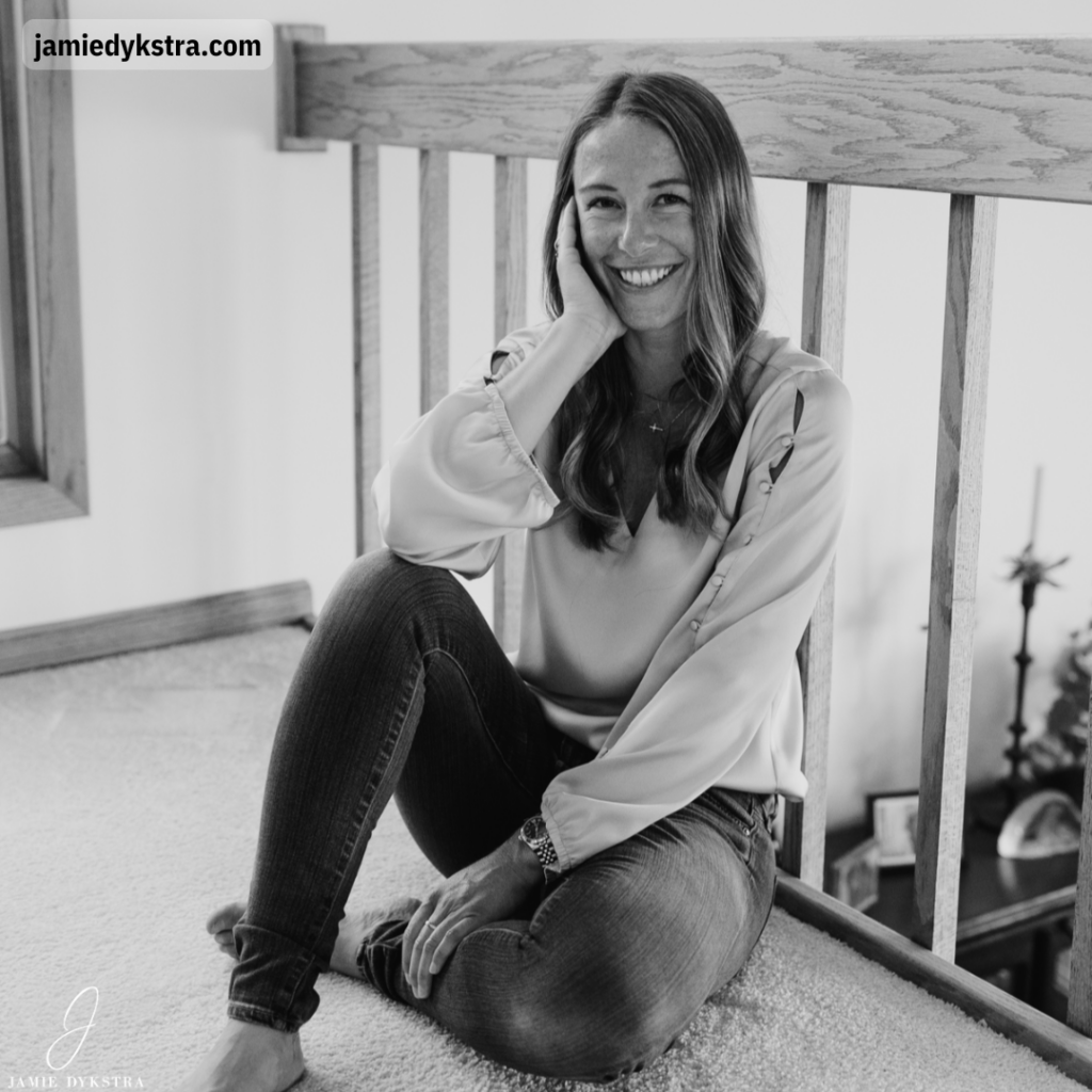 A black and white picture of me sitting on the floor leaning again spires of a railing.
