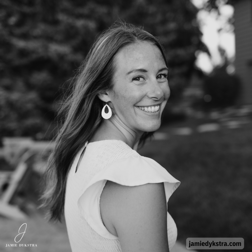 A black and white photo of me looking back over my shoulder in a short sleeve sundress.