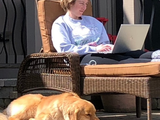 A photo of me in a lounge chair with my laptop and golden retriever laying next to me. I'm wearing a gray sweatshirt and black leggings.