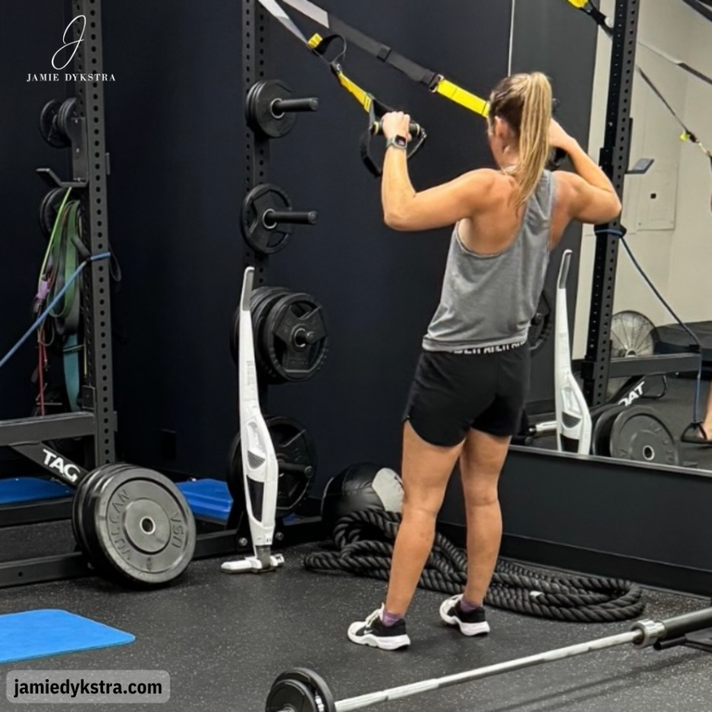 A photo of me using the TRX bands in a gym.