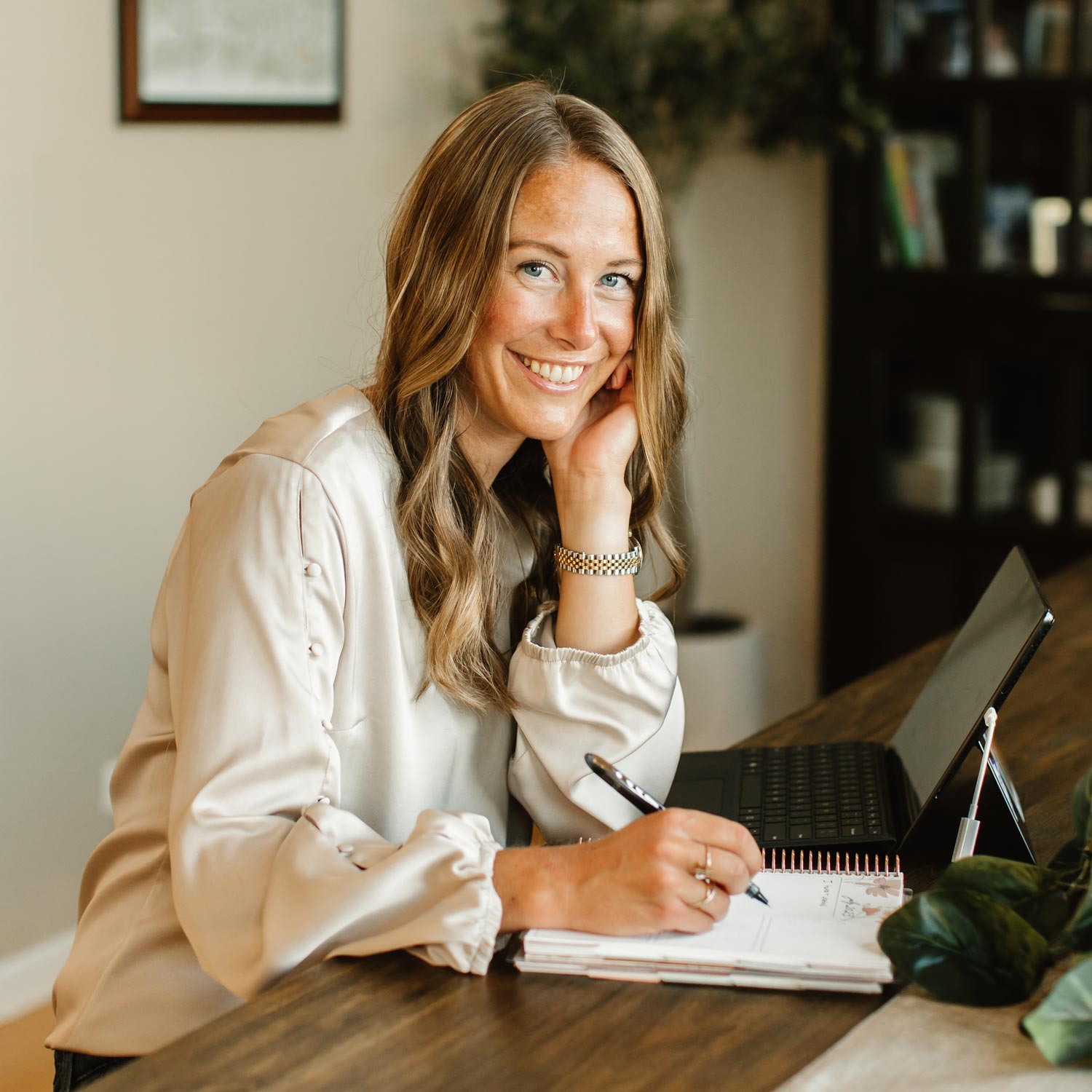 Jamie Dykstra, Ghostwriter, sitting at a table with a laptop and a notebook.