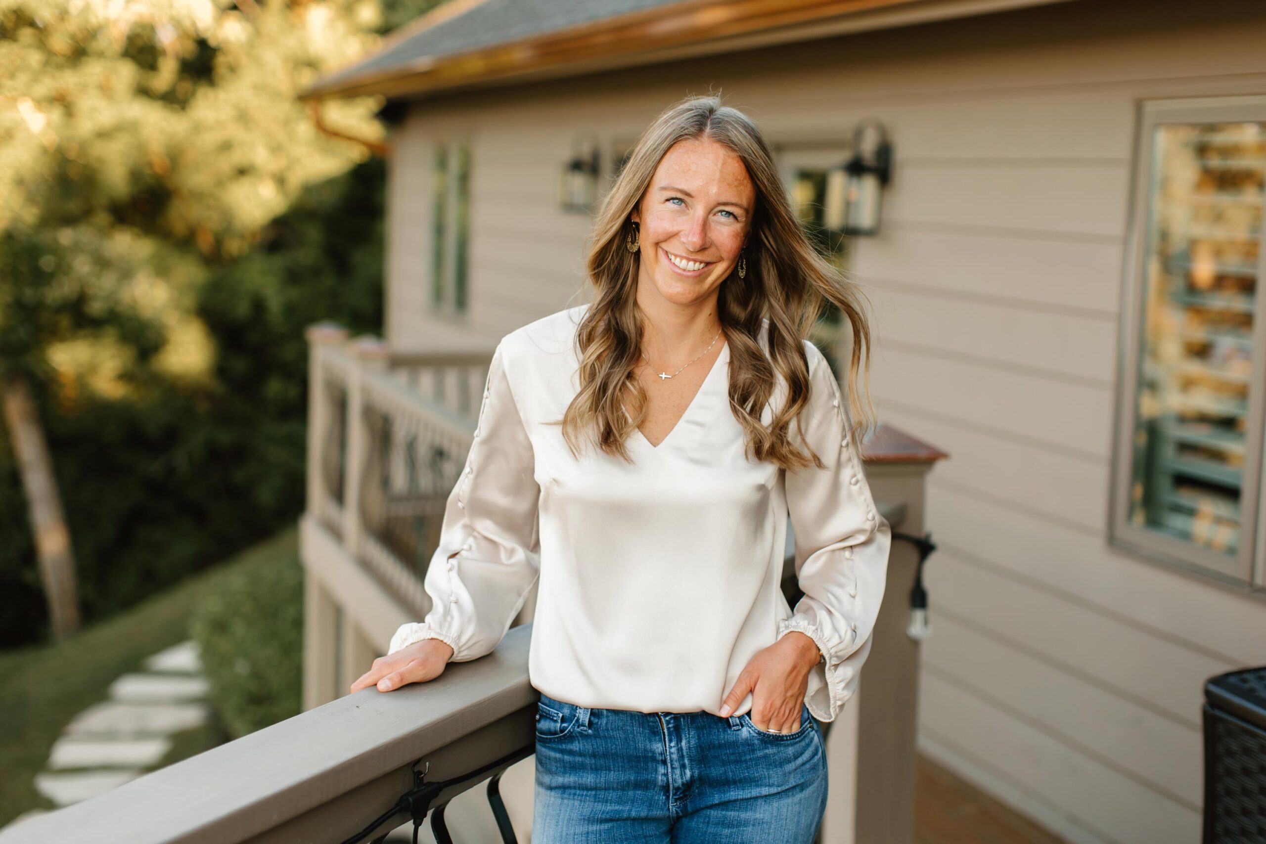 Jamie Dykstra, non-fiction ghostwriter and keynote speaker, standing on a deck outside