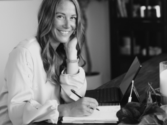 A black and white photo of me sitting at a table with my laptop and a notebook.