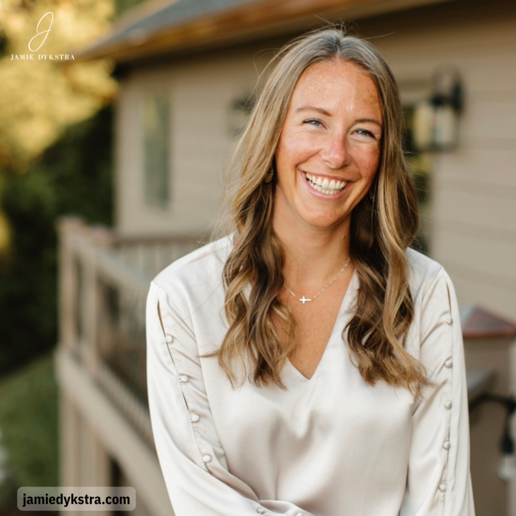 A photo of me standing on the back deck of a house with a silk cream shirt on, and I'm laughing.