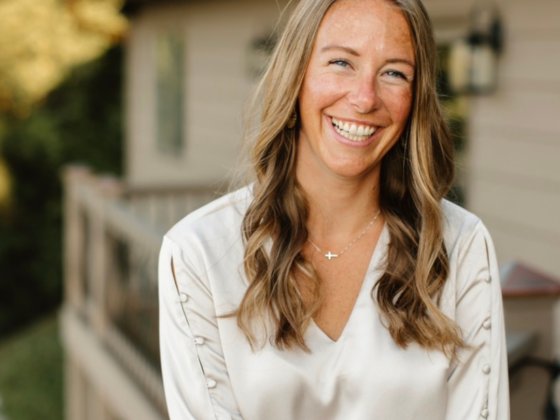 A photo of me standing on the back deck of a house with a silk cream shirt on, and I'm laughing.