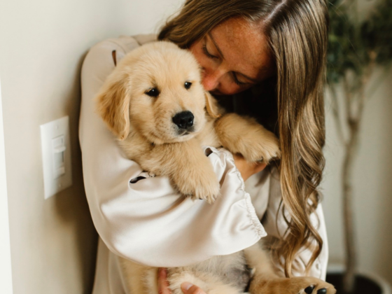 A photo of me holding a golden retriever puppy and kissing his ear.