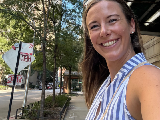 A photo of me taking a selfie on a city sidewalk in a blue and white striped dress.